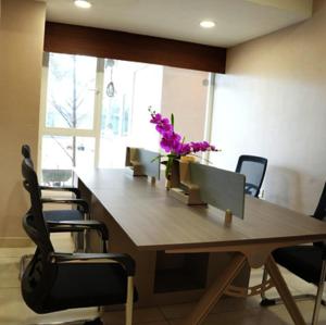 an office with a large wooden table with chairs and flowers at Nilayat Inn in Ollūr