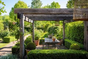 a wooden pergola with a table in a garden at Miss Martinellis in Beechworth