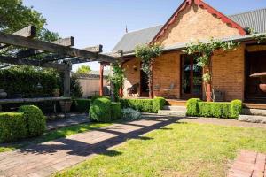 a brick house with a garden and a patio at Miss Martinellis in Beechworth