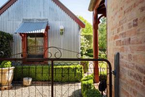 a black cat standing in front of a gate at Miss Martinellis in Beechworth