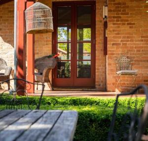 a bird sitting on a bench in front of a door at Miss Martinellis in Beechworth