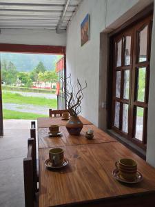 a wooden table with two cups and a vase on it at La Posta de Don Calixto in León