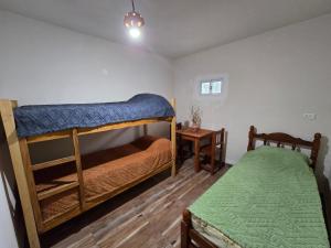 a bedroom with two bunk beds and a table at La Posta de Don Calixto in León