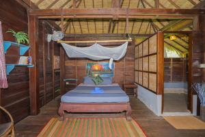 a bedroom with a bed in a wooden house at Khmer Hands in Kep