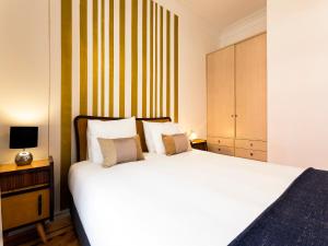 una camera con un grande letto bianco e un armadio di WHome | Damasceno Contemporary Apartment #59 a Lisbona