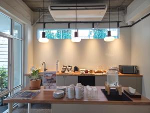 a kitchen with a table and a counter with dishes at Warm Pillow Hotel Bangkok in Bangkok