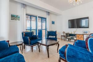 a living room with blue chairs and a tv at Seaview Sanctuary House in Larnaca +29 photos
