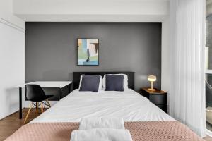 a bedroom with a large bed and a desk at Eleve Toronto Residences in Toronto