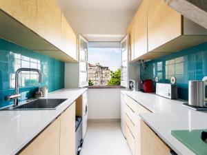 リスボンにあるWHome | Damasceno Contemporary Apartment #59のキッチン(木製キャビネット付)、大きな窓が備わります。