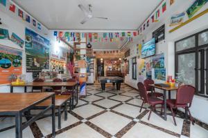 a restaurant with tables and chairs and flags on the walls at Lola's House in Ha Long