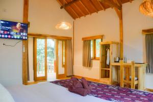a bedroom with a bed and a tv on the wall at Beda gaya ecolodge Rangsot 3 in Tanjung