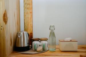 a wooden shelf with jars and a bottle on it at Beda gaya ecolodge Rangsot 3 in Tanjung
