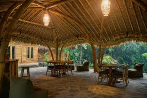 a dining room with tables and chairs in a large tent at Beda gaya ecolodge Rangsot 3 in Tanjung