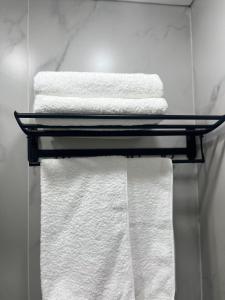 a group of towels on a towel rack in a bathroom at Апартамент в центре Арбата in Shymkent
