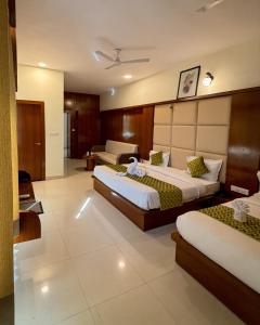a hotel room with two beds and a couch at New Crown Plaza in Jodhpur