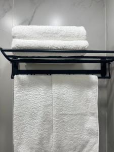 a stack of towels on a towel rack in a bathroom at Апартамент в центре Арбата in Shymkent +2 photos