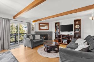 a living room with a fireplace and a tv at Woodbridge 21C in Snowmass Village