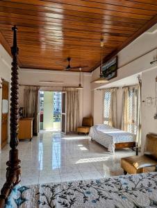 a bedroom with a bed and a wooden ceiling at MARVellous Guest House in Dibrugarh +11 photos