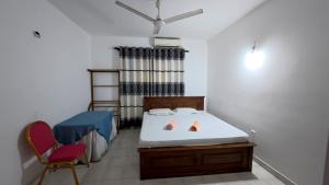 a small bedroom with a bed and a chair at Shehan's Hotel Maharagama in Maharagama
