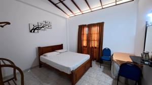 a bedroom with a bed and a table and chairs at Shehan's Hotel Maharagama in Maharagama