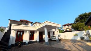 a white house with a car parked in front of it at Shehan's Hotel Maharagama in Maharagama