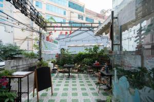 an outdoor patio with tables and chairs and plants at Lola's House in Ha Long