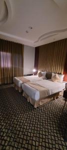 a hotel room with two beds in a bedroom at سهول بارك in Riyadh +3 photos
