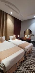 a hotel room with two beds and a desk at سهول بارك in Riyadh