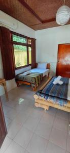 a room with two beds and a window at Secret Garden Bungalows in Nusa Lembongan +24 photos