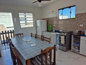 a kitchen with a table and chairs and a kitchen with a stove at Quarto casal Nereidas bwc compartilhado in Guaratuba