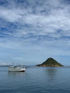 a boat in the water next to an island at Sehat Elona Adventure in Lombok