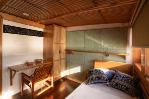 a bedroom with a bed and a table and a desk at Sehat Elona Adventure in Lombok