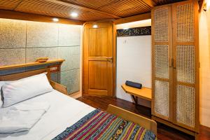 a bedroom with a bed and a table and a door at Sehat Elona Adventure in Lombok
