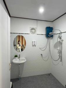a woman taking a picture of a bathroom with a sink at หลงใหล ภูทับเบิก in Ban Maeo Thap Boek
