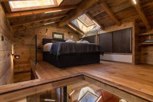 a bedroom with a bed in a room with wooden floors at Mazot du Mont-Blanc w/View, Terrace & Stove, (Sleeps 4) - Happy Rentals in Chamonix