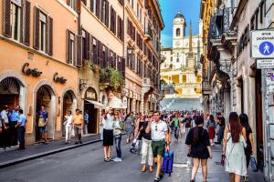 a crowd of people walking down a street with buildings at Les Fleurs Luxury House in Rome