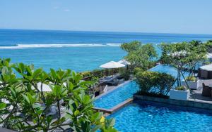 an infinity pool with the ocean in the background at Samabe Bali Suites & Villas in Nusa Dua