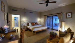 Un dormitorio con una cama y una sala de estar. en Barahi Jungle Lodge, en Meghauli 37 fotos más