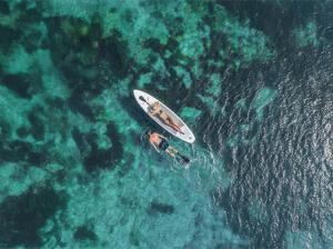 an aerial view of a man in a boat in the water at Samabe Bali Suites & Villas in Nusa Dua