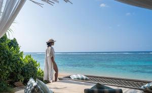 a woman standing on the beach looking out at the ocean at Samabe Bali Suites & Villas in Nusa Dua