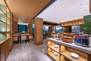an open kitchen and dining room with tables and chairs at Manxin Hotel Nanjing Mufu Mountain in Nanjing