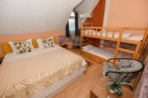 a bedroom with two bunk beds and a chair at Lagúna Panzio Szántód in Szántód