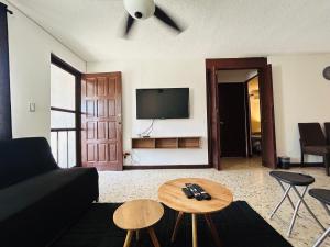 a living room with a couch and a tv at Comfortable apartment 10 min BBVA Stadium - Wi-fi Parking SmartTV & AC in Monterrey