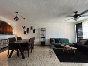 a living room with a green couch and a table at Comfortable apartment 10 min BBVA Stadium - Wi-fi Parking SmartTV & AC in Monterrey