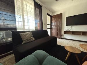 a living room with a couch and a tv at Comfortable apartment 10 min BBVA Stadium - Wi-fi Parking SmartTV & AC in Monterrey +14 photos