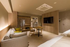 a hotel room with a bed and a couch and a table at Sumu Ueno East in Tokyo