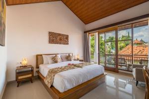a bedroom with a bed and a large window at Amantra Ubud in Ubud +33 photos