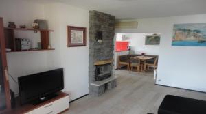 a living room with a television and a fireplace at Apartment Ružmarin Porat in Porat