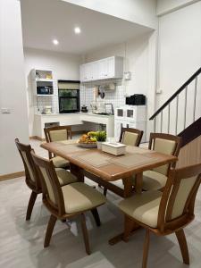 a kitchen and dining room with a wooden table and chairs at Ama'home in Hat Yai