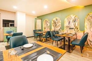 a dining room with tables and chairs and a wall with mirrors at Treebo Aurum Leaf in Nagpur